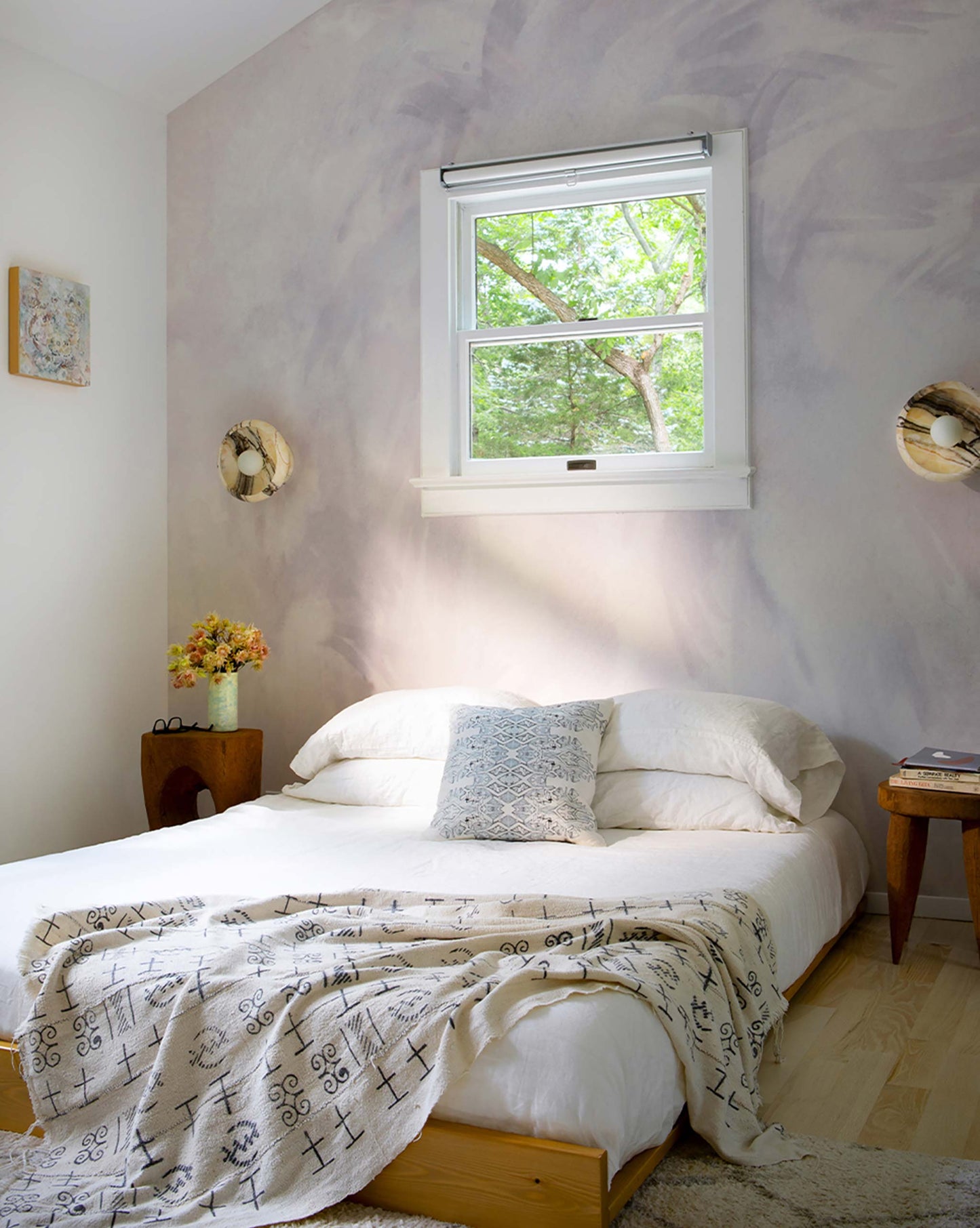 A bedroom with Eskayel's Reflettere Wallpaper Mural in the colorway Alba installed as an accent wall.