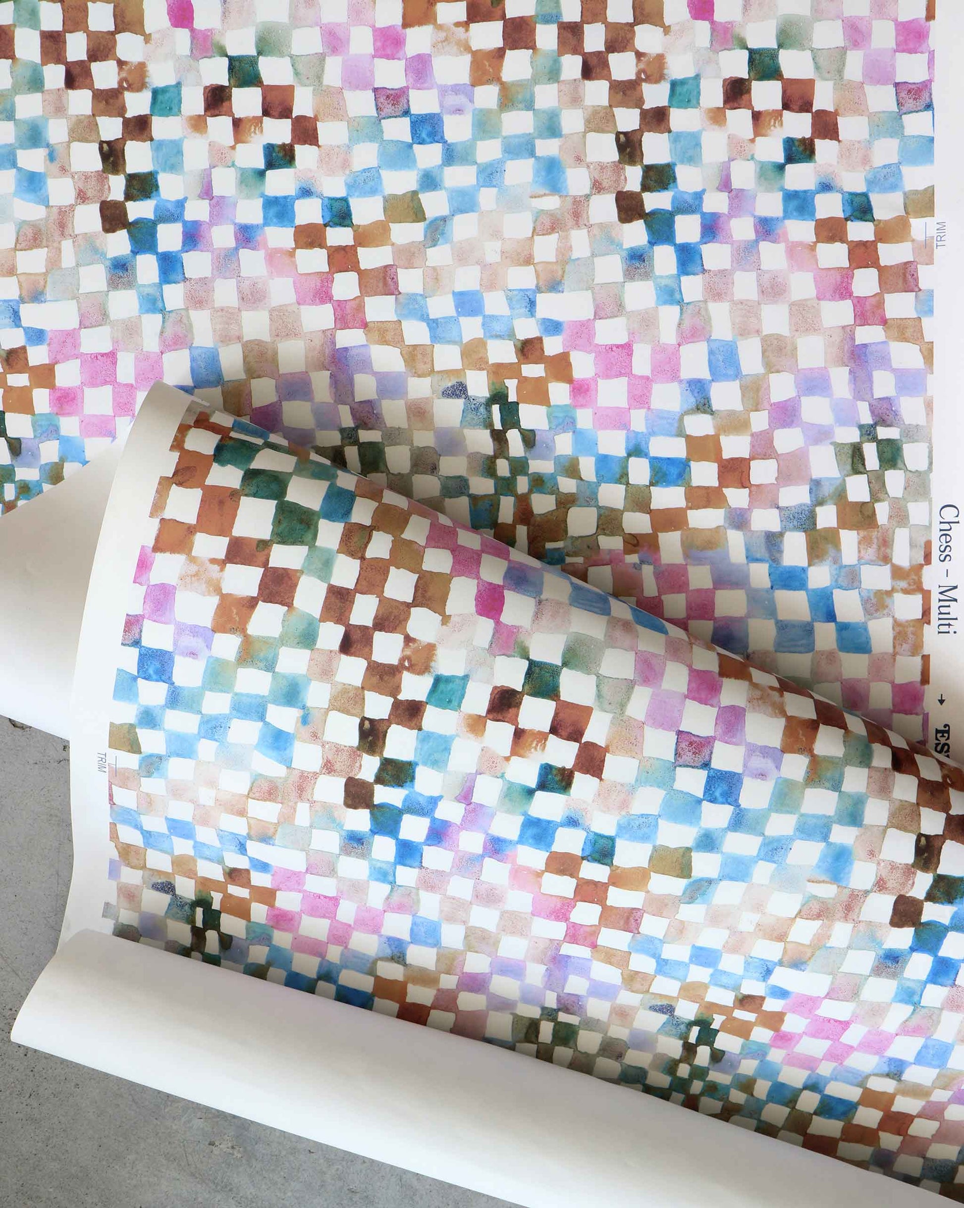 A roll of Chess Wallpaper Multi on top of a table