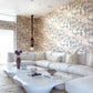 Modern living room with Clemente Wallpaper||Sol, a large white sectional sofa, unique white coffee tables, decorative books, and a hanging pendant light.