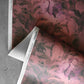 A detail shot of Cocos Wallpaper in the colorway Persimmon which features a red and pink color.