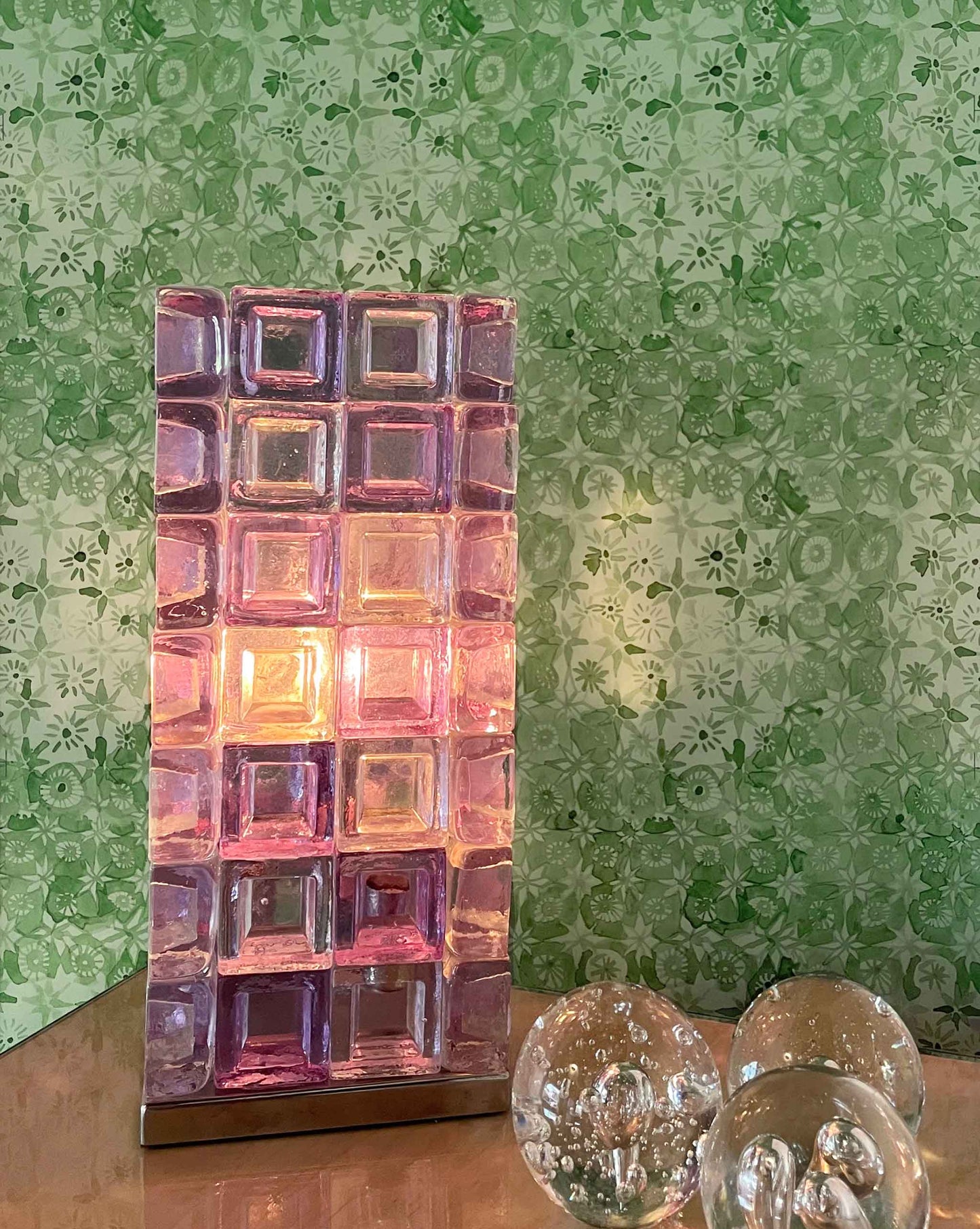 Decorative purple glass light with our crochet lace wallpaper in the colorway arugula. 