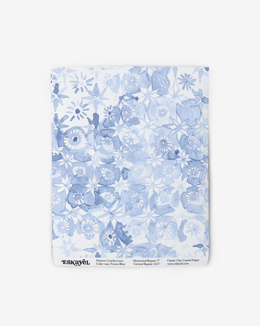 Crochet Lace wallpaper draws on Italy’s textile heritage. A swatch of the Fresco Blue colorway features blues and white.