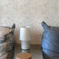 A white lampshade on a mirrored side table against Eskayel's crochet lace pattern in the colorway ricotta.