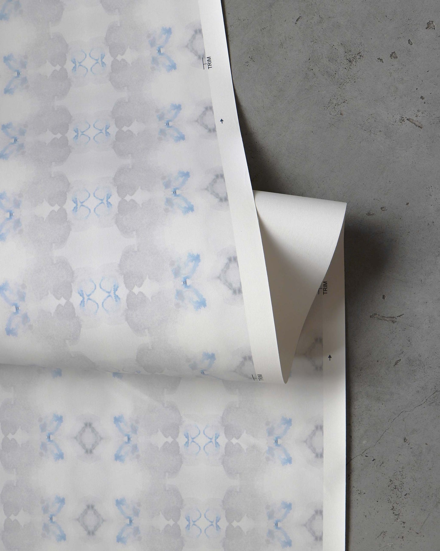 A detail shot of Icelandic Mist Wallpaper in the colorway Sea Green which features a white and blue pattern.