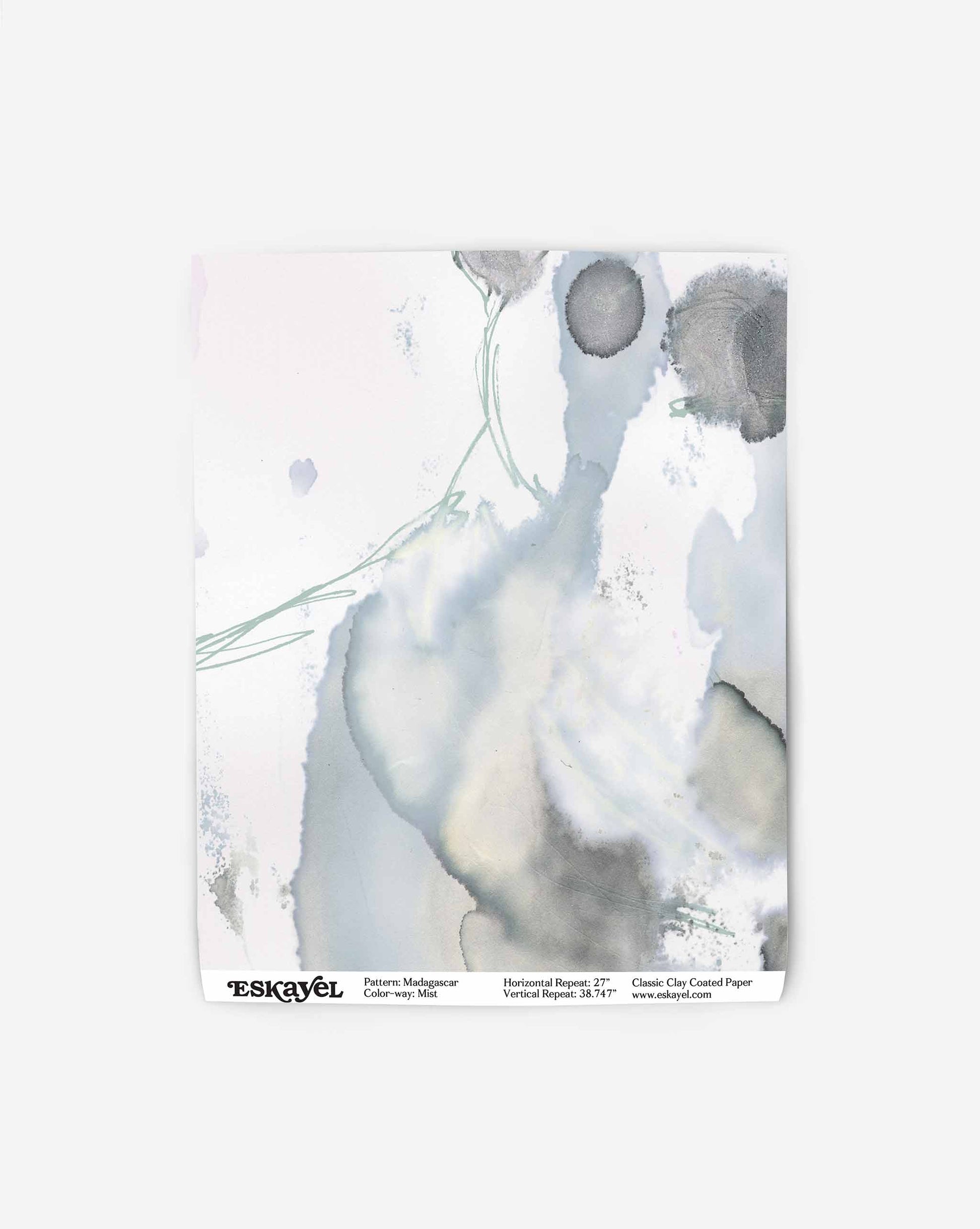 Abstract watercolor painting with shades of gray, blue, and green, featuring organic shapes and fluid patterns, set against a white background. Resembling high-end wallpaper designs, text at the bottom includes brand and product details: Madagascar Wallpaper||Mist.