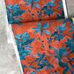 A detail wallpaper photo of Plumeria Shadows pattern in Hibiscus, a medium-sized repeat in the colorway featuring rich red background and gold tone leave | Eskayel