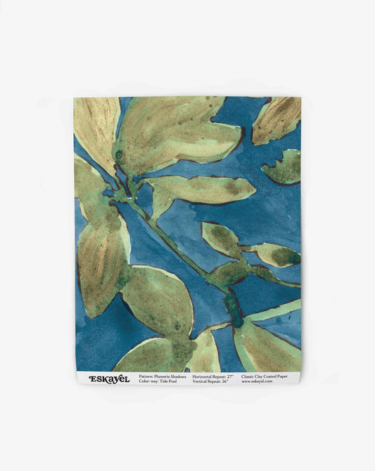 A wallpaper swatch image of Plumeria Shadows pattern in Tide Pool, a colorway featuring a deep blue background and green leaves | Eskayel