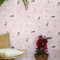 Eskayel's Swim wallpaper in the colorway Shell in pink with waterborne female figures installed as an accent wall with a vase of flowers and a wooden stool.