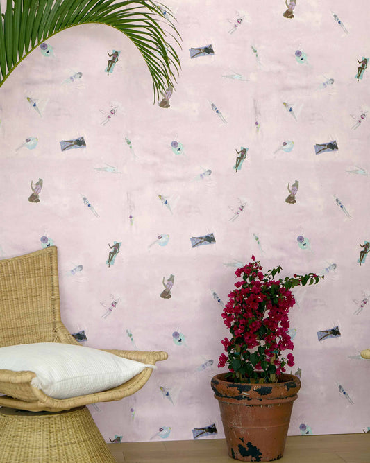 Eskayel's Swim wallpaper in the colorway Shell in pink with waterborne female figures installed as an accent wall with a vase of flowers and a wooden stool.