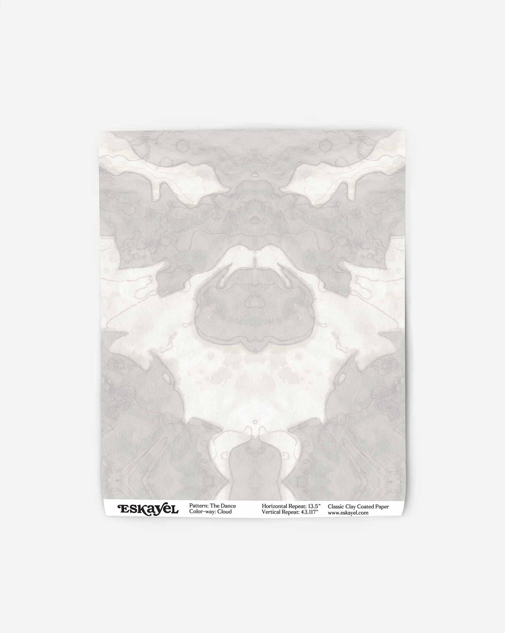White and gray abstract inkblot pattern on a rectangular sheet of paper with "The Dance Wallpaper||Cloud" and other text printed at the bottom, part of the Lora Collection.