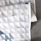A roll of Triangle Checks Wallpaper Ocean with a pattern of geometric sequences from the Triangle Checks collection on it