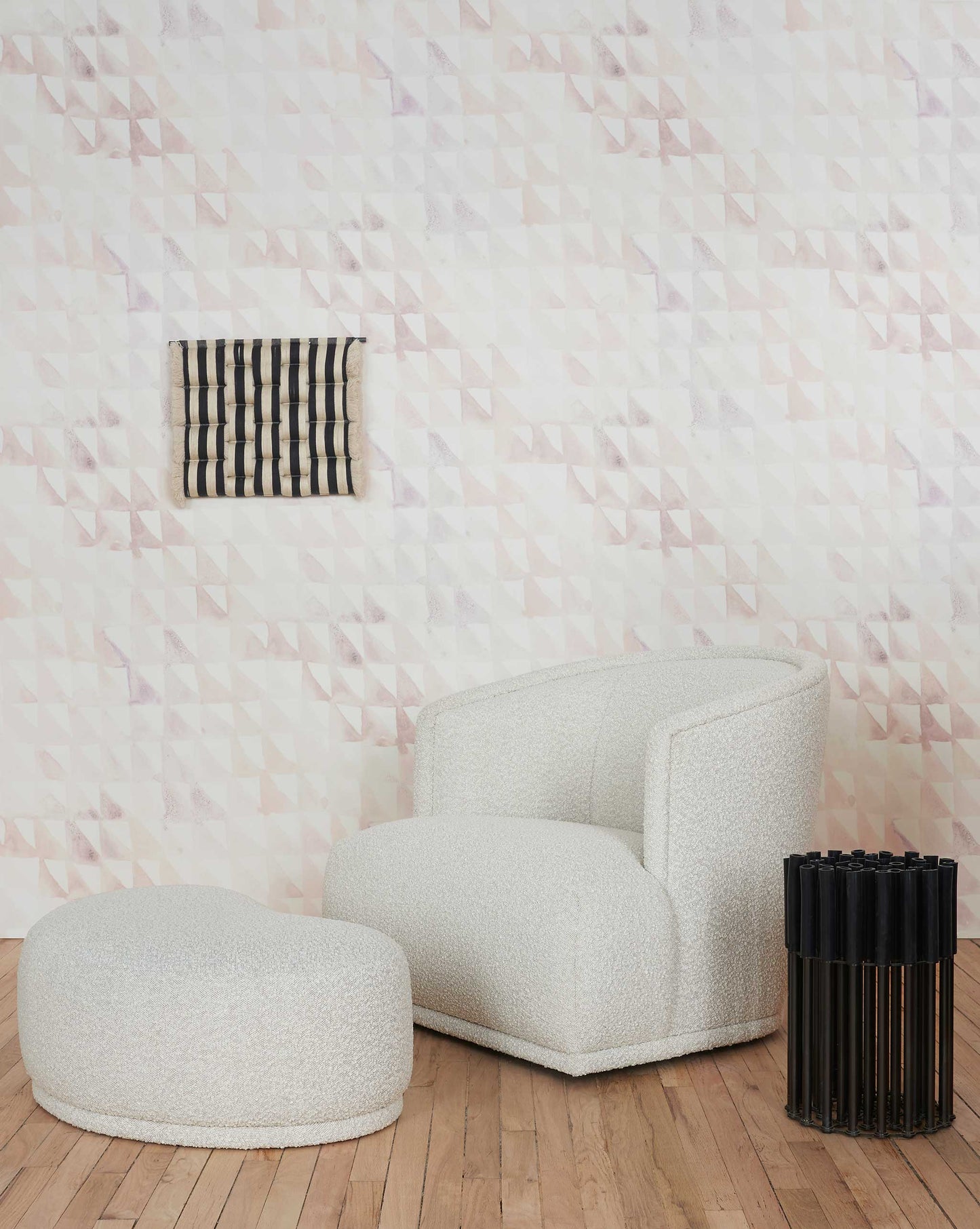A white chair and ottoman in front of Triangle Checks Wallpaper Sol