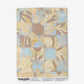 Yaya wallpaper in Husk as a swatch — beach-themed graphic botanical wallpaper in creamy yellow, earthy brown, and light blue | Eskayel