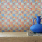 Yaya wallpaper in Punch installed in a room — beach-themed graphic botanical wallpaper in bright pink, peach, periwinkle blue, and pale turquoise | Eskayel