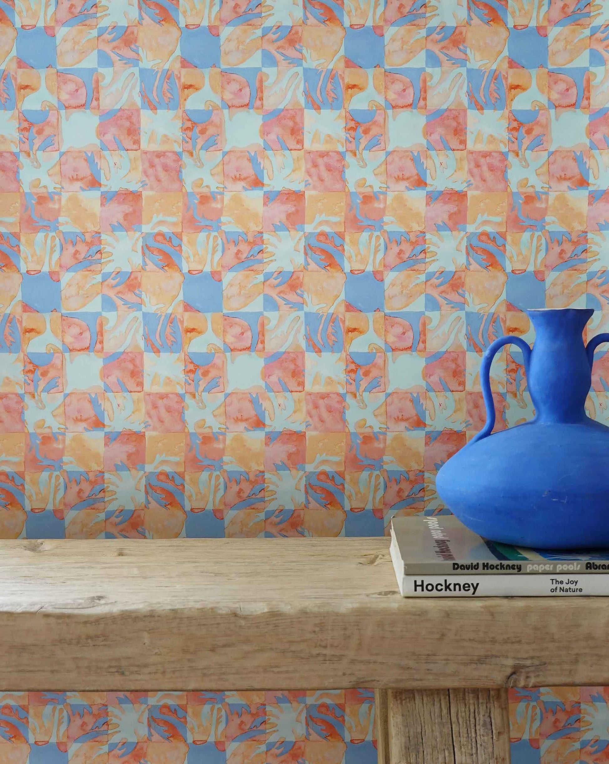 Yaya wallpaper in Punch installed in a room — beach-themed graphic botanical wallpaper in bright pink, peach, periwinkle blue, and pale turquoise | Eskayel