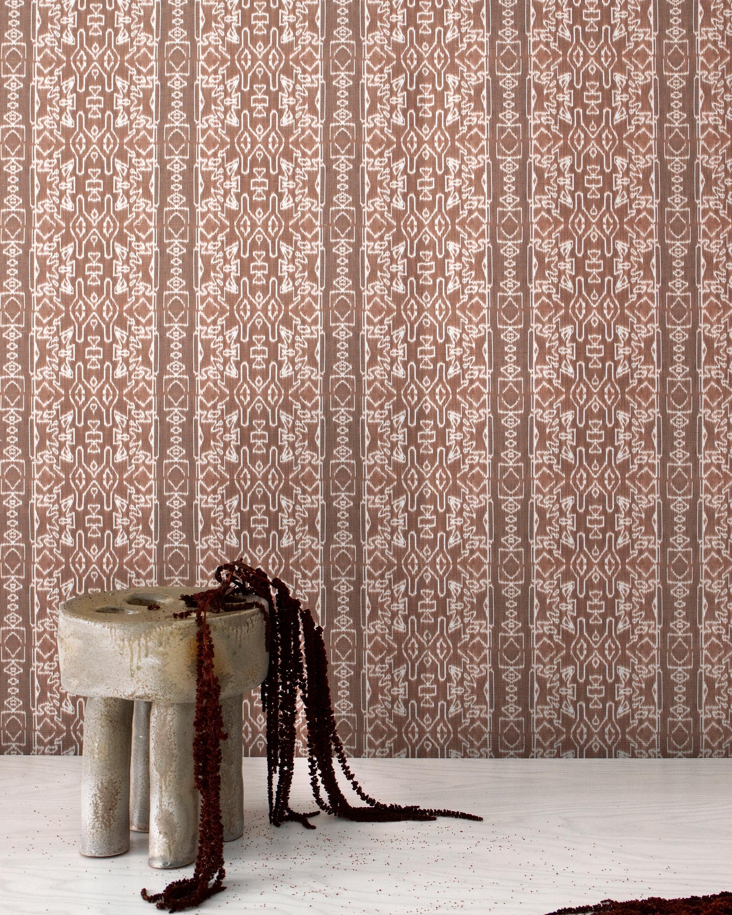 A brown and white Akimbo Grasscloth Morinda Ikat design with a stool in front of it
