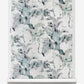 A roll of Cocos Grasscloth wallpaper with palm tree motifs in a blue and white floral pattern