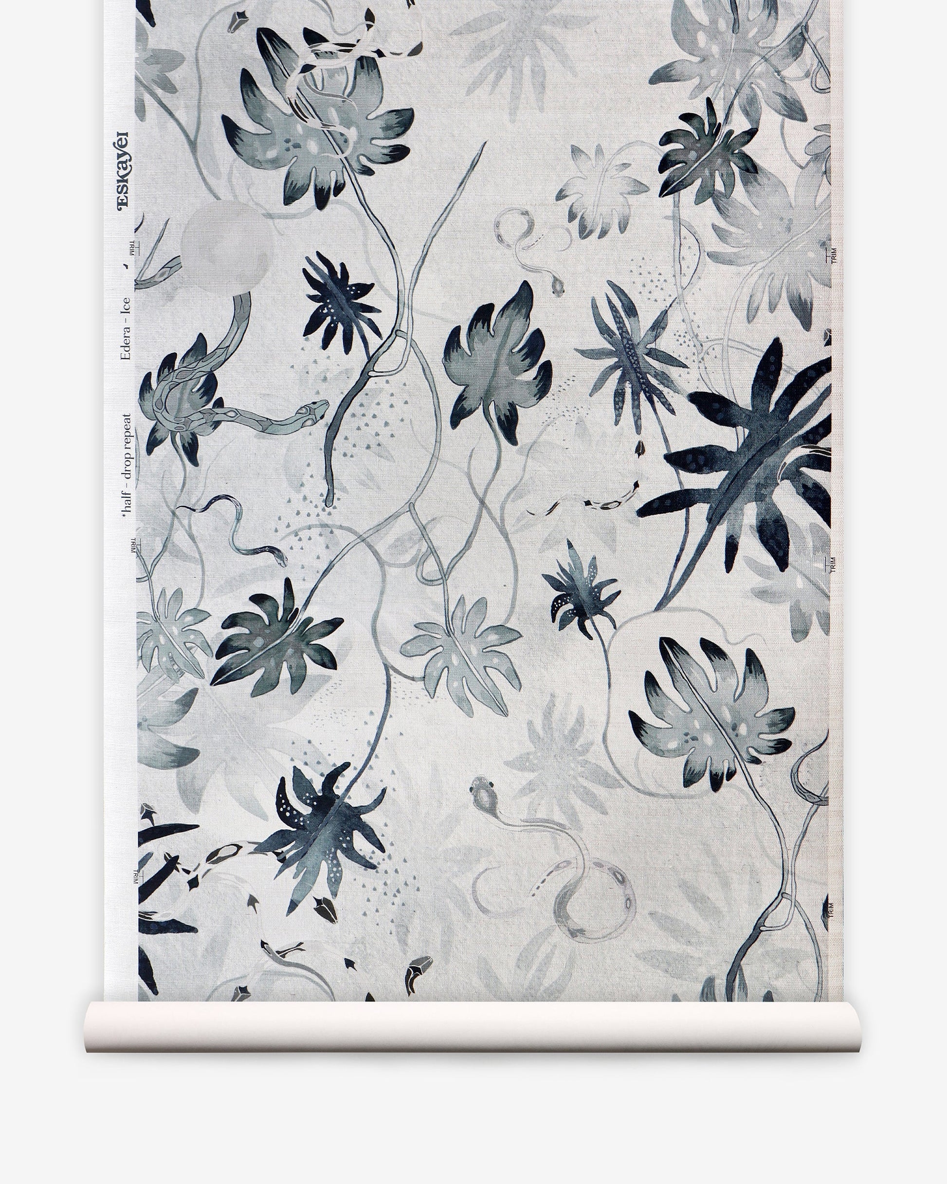 A roll of Edera Grasscloth Ice with chinoiserie-inspired black and white flowers on it