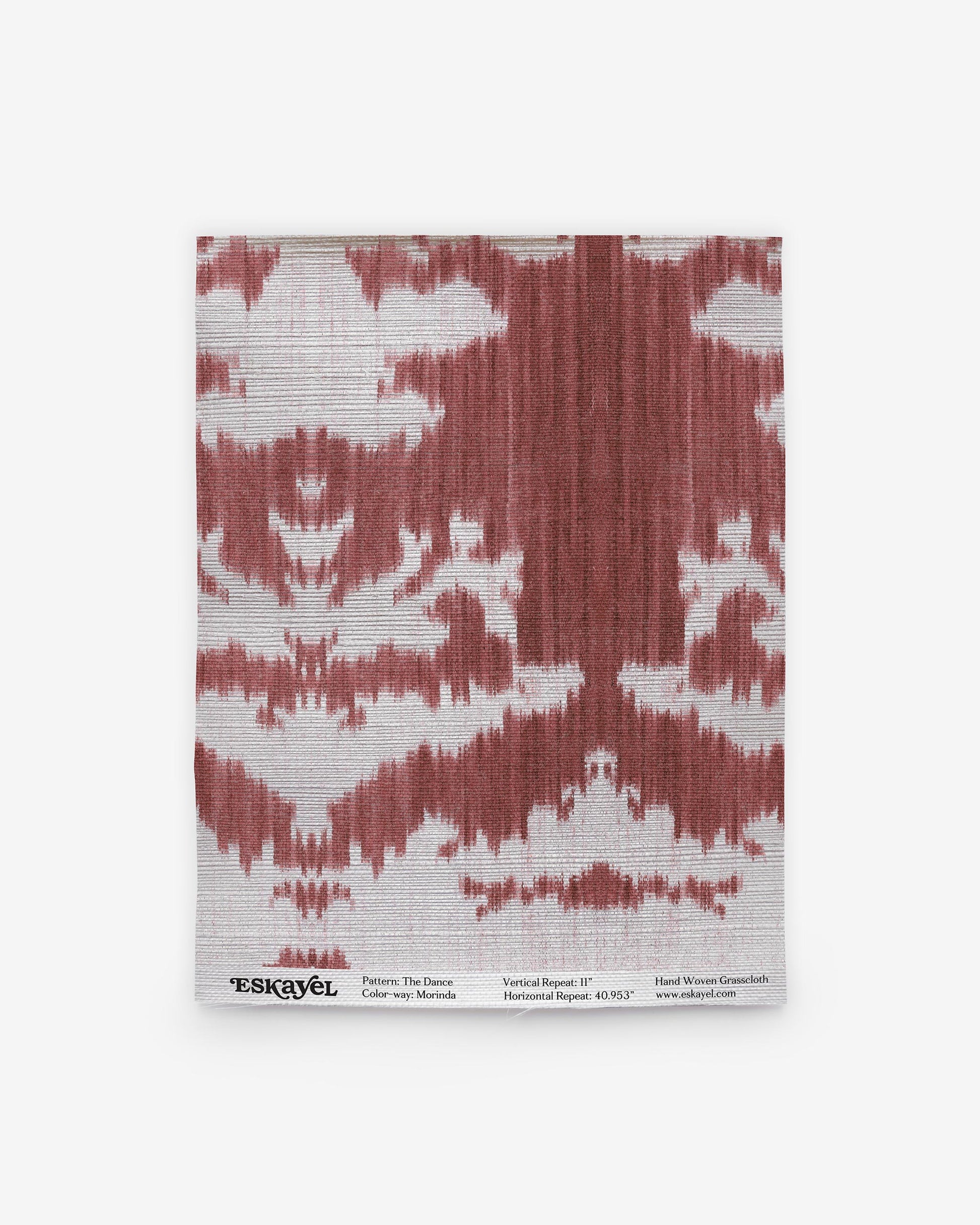 A red and white The Dance Grasscloth Morinda Ikat pattern on a grasscloth wallcovering