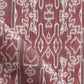 A close up of a red and white Akimbo Fabric with a graphic geometric pattern