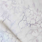 A white and purple marble pattern on a piece of Aquarelle Fabric Ice