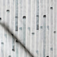 A close up of a grey and white fabric with black and white Eskayel Bamboo Stripe Fabric Slate pattern
