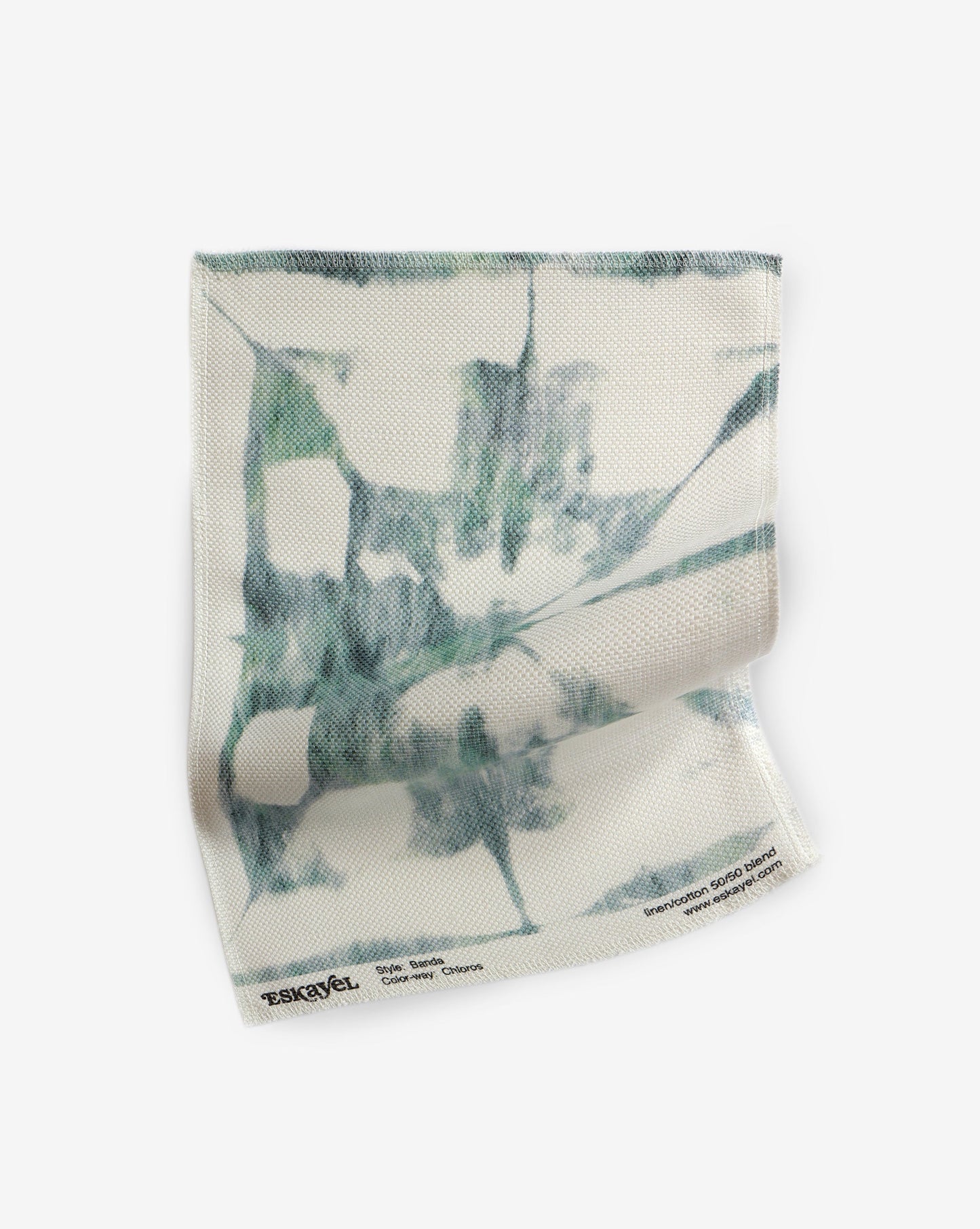 A tea towel with a green and blue Banda Fabric||Chloros design.