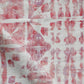 A red and white Banda Fabric with a tie-dye pattern on it.