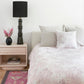 A bedroom with a pink bed and pink pillows made of Emvasia Fabric Alba