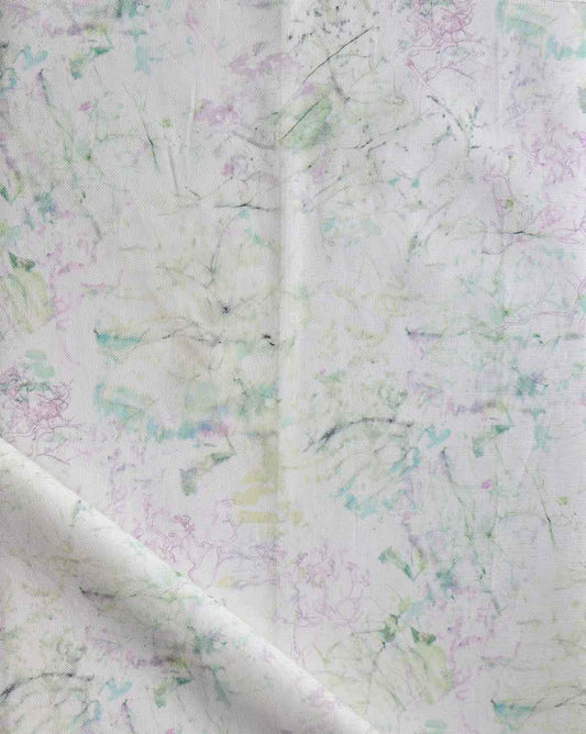 A white fabric with green and purple flowers, Bosky Toile Fabric Cay, on it