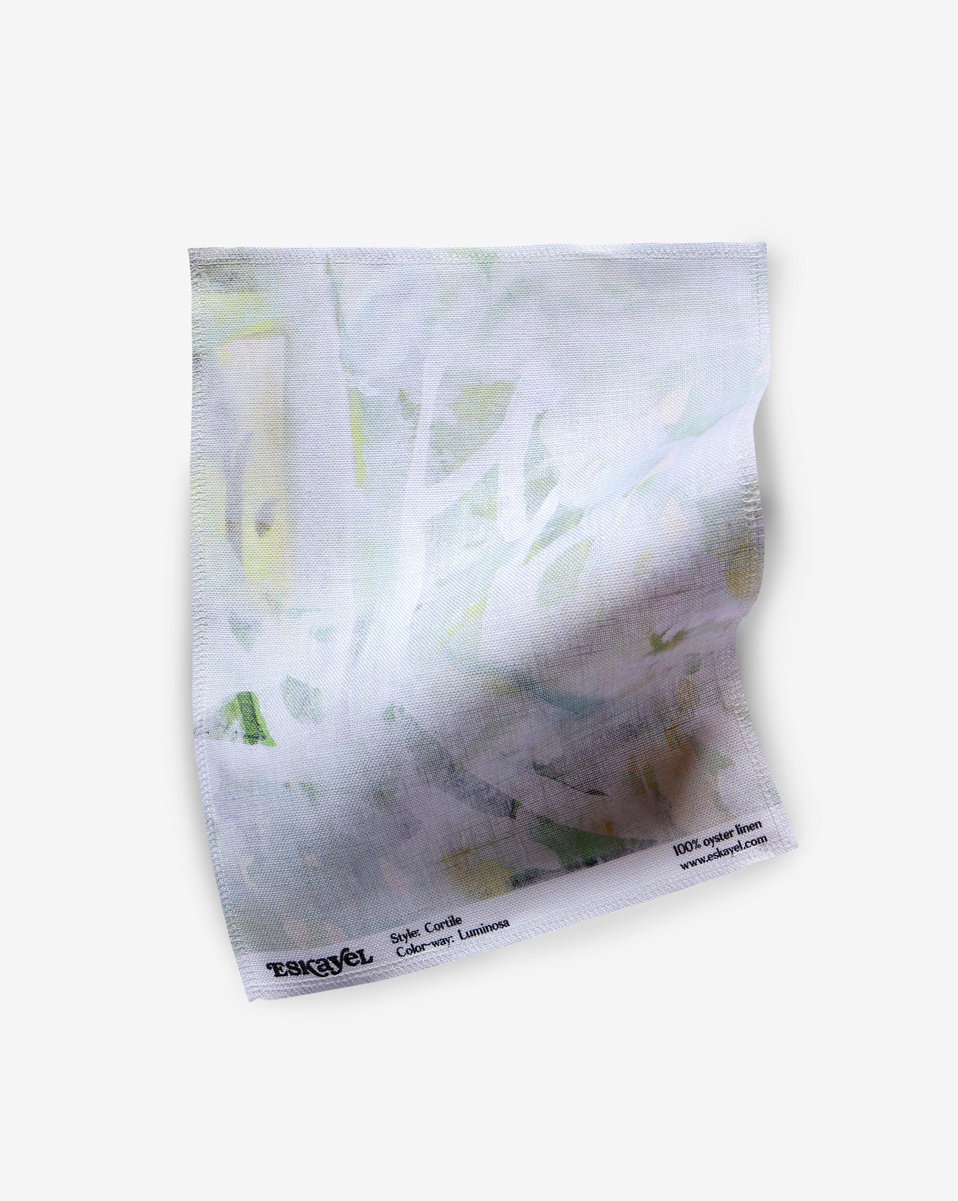 A piece of Cortile Fabric Luminosa with white and green paint on it