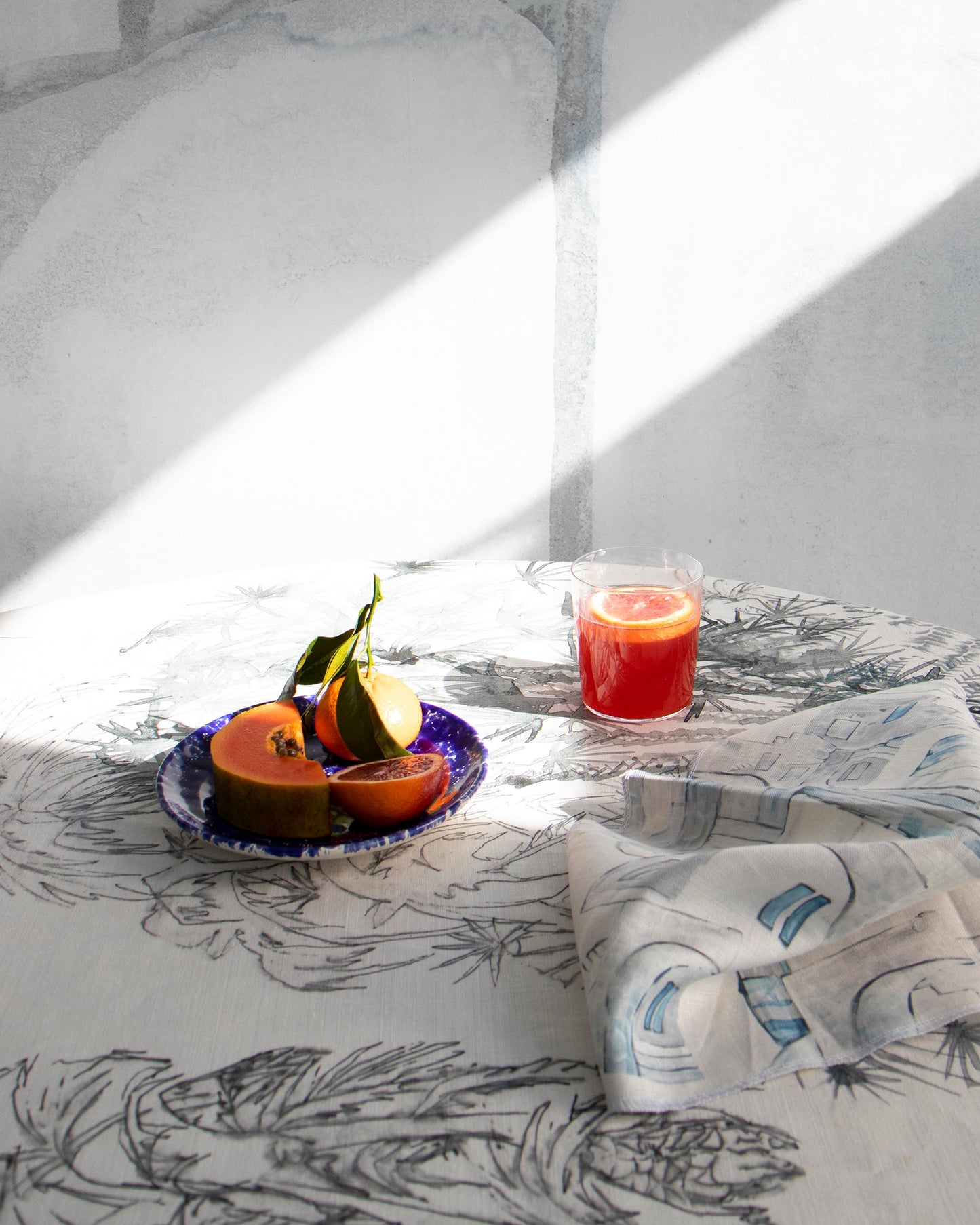A plate of fruit on a table with a luxurious fabric from the Salentu Collection and the Domenica Fabric Notte