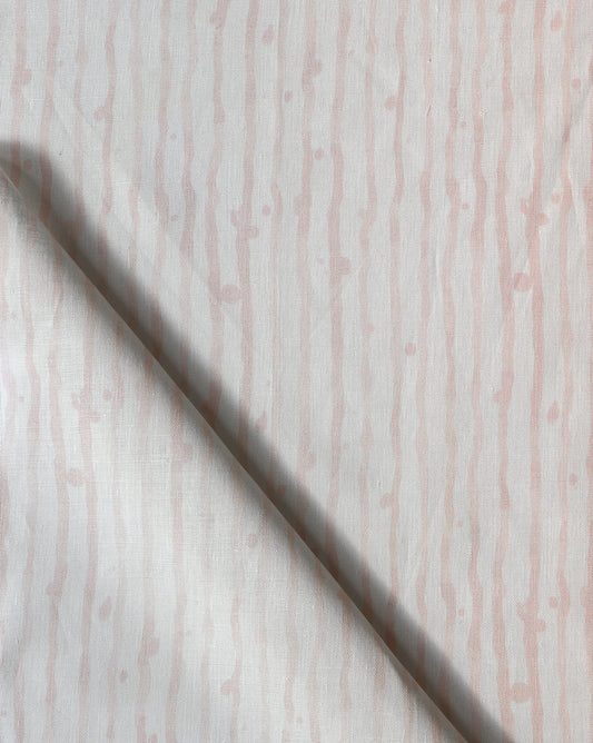 A Drippy Stripe Fabric Coral on a white surface