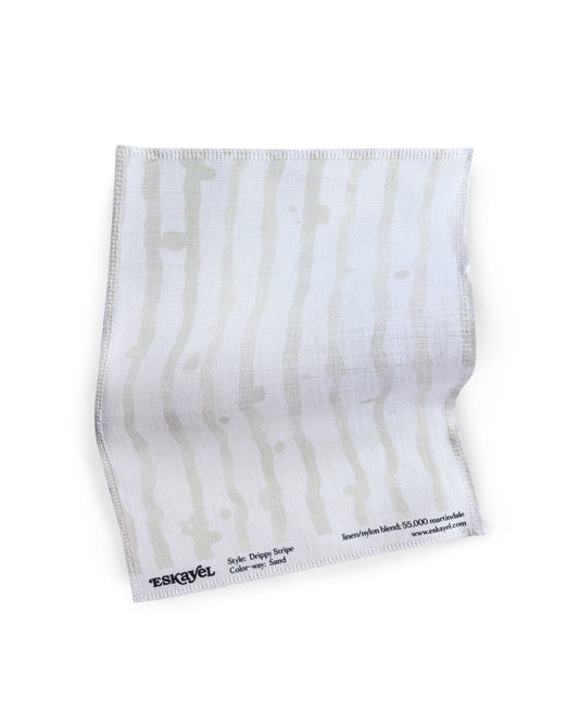 A white fabric with Drippy Stripe Fabric Sample Sand on it