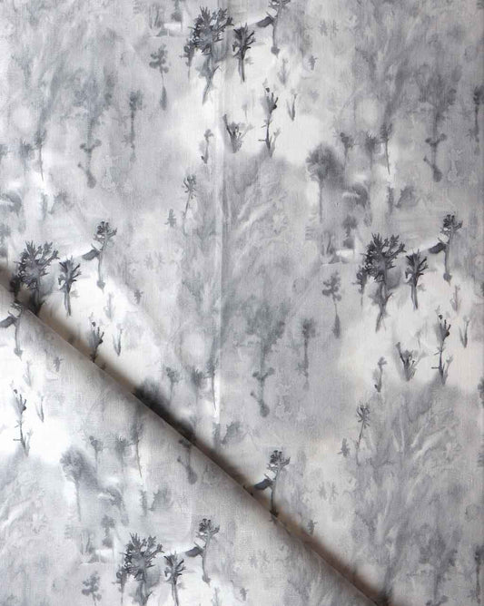 An Emvasia Fabric Phyllite microprint wallpaper featuring a grey and white fabric with trees on it
