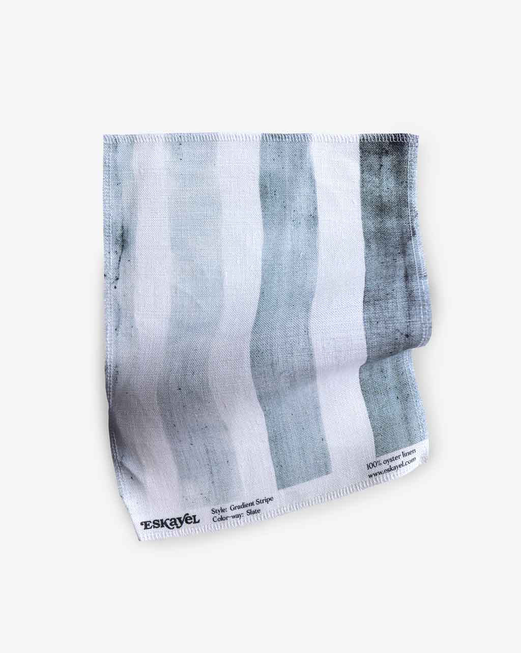 A blue and white striped Gradient Stripe Fabric Slate on a white surface