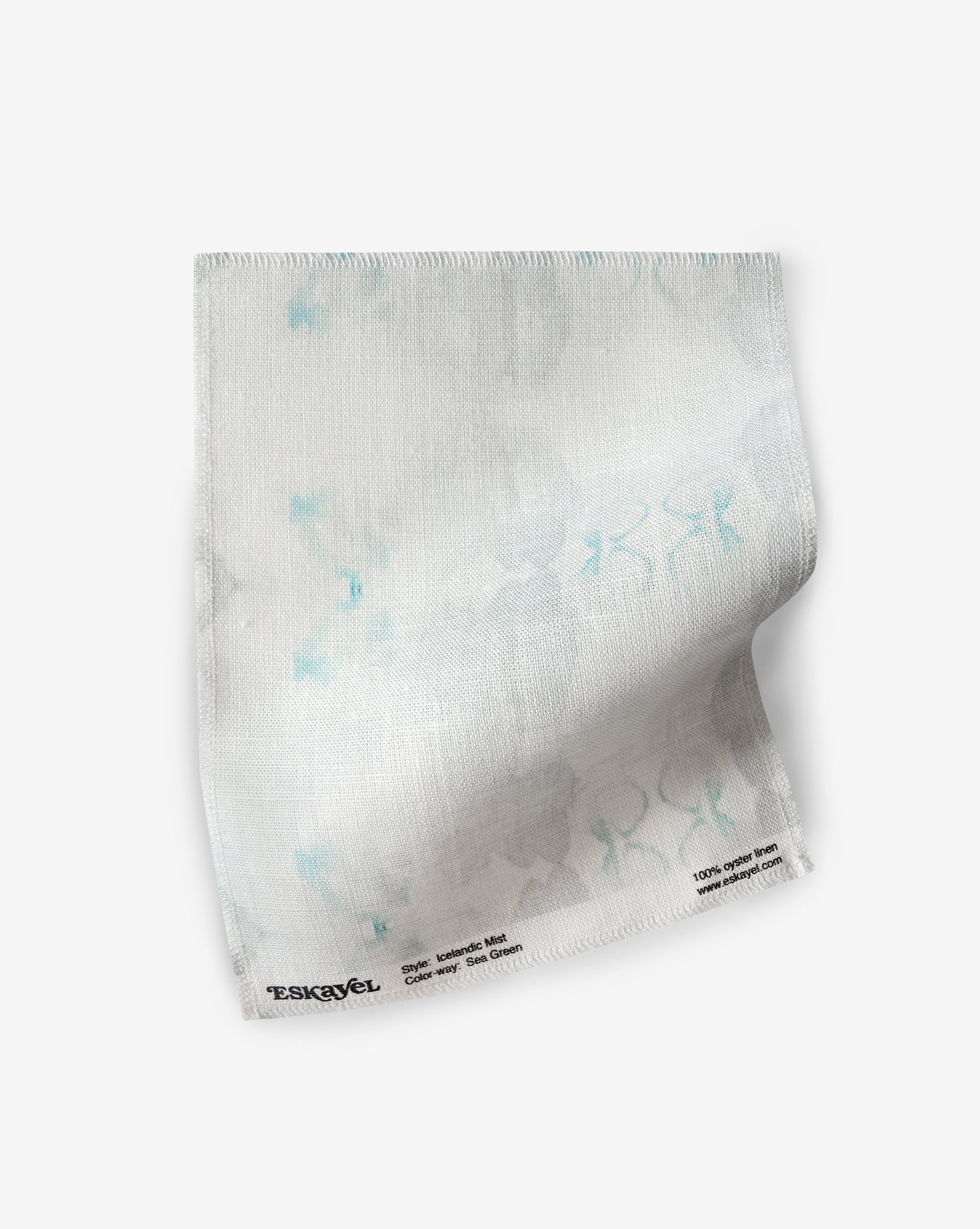 A white fabric with Icelandic Mist Fabric Sample Sea Green and white flowers on it