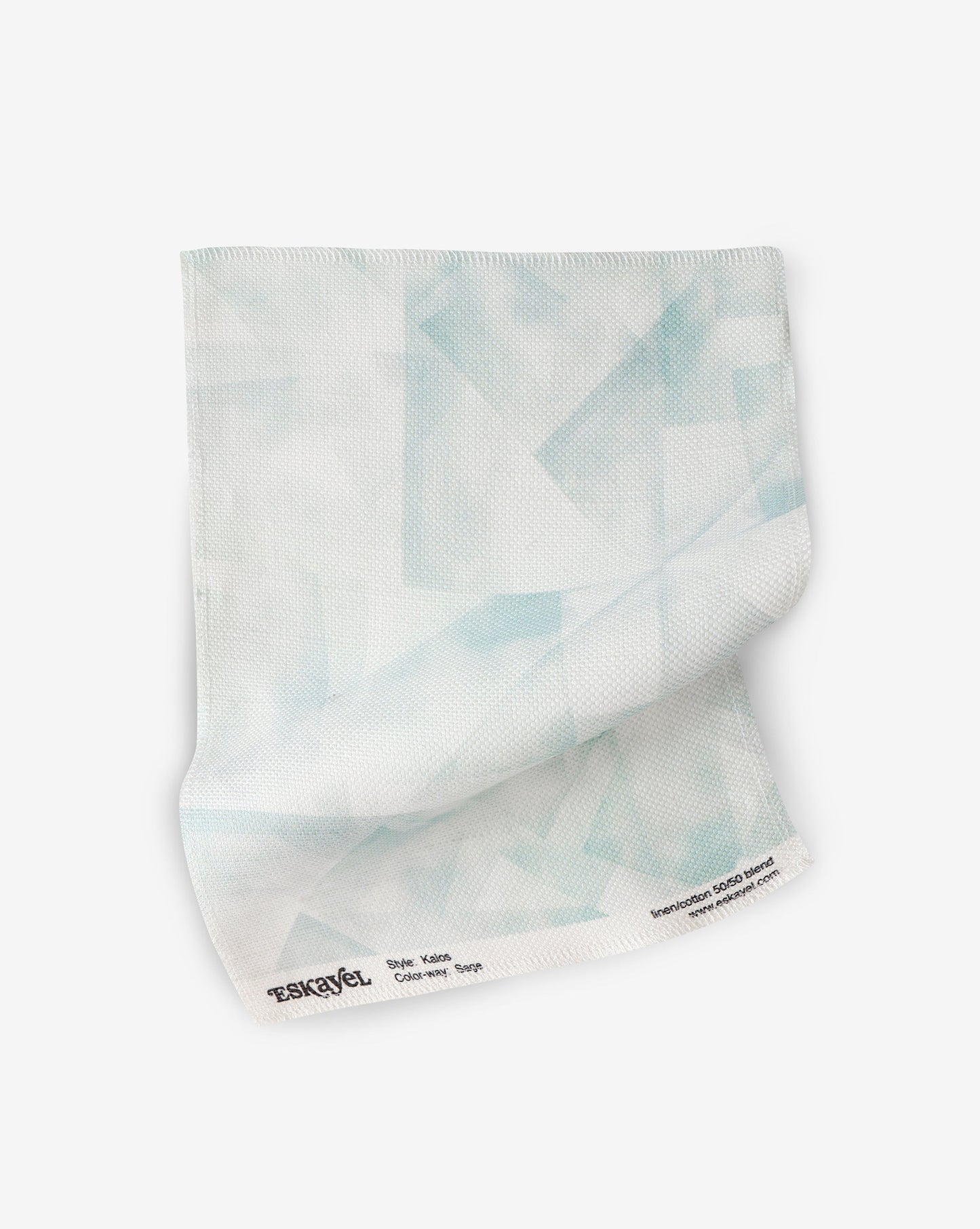 A white Kalos Fabric||Sage towel adorning blue triangles, inspired by the Canadian Pacific Northwest.