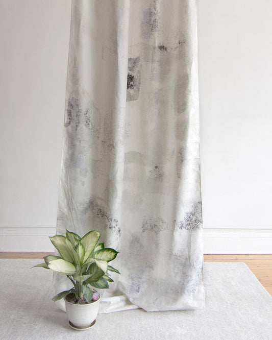 A white curtain with a plant on it made of Kotoubia Fabric Blanca