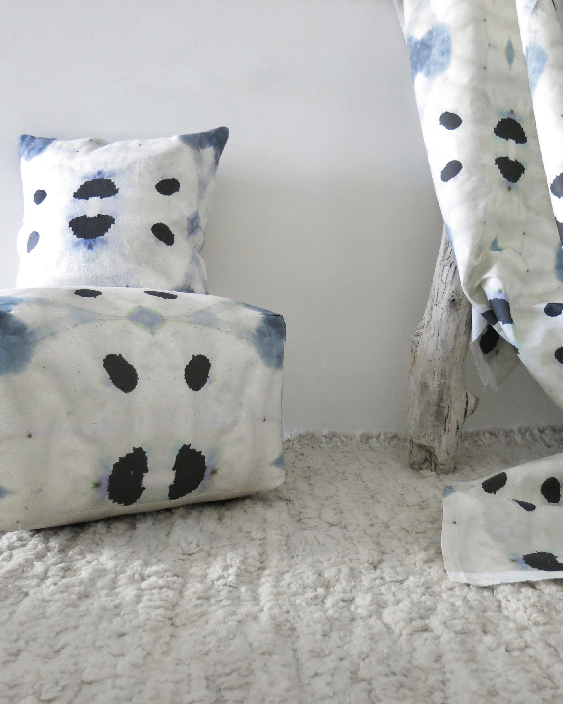 A blue and white Galileo Glass Fabric Shale pillow with an abstract polka dot pattern