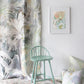 A Regalo di Dio Fabric Verde chair in front of a wall with coastal living wallpaper