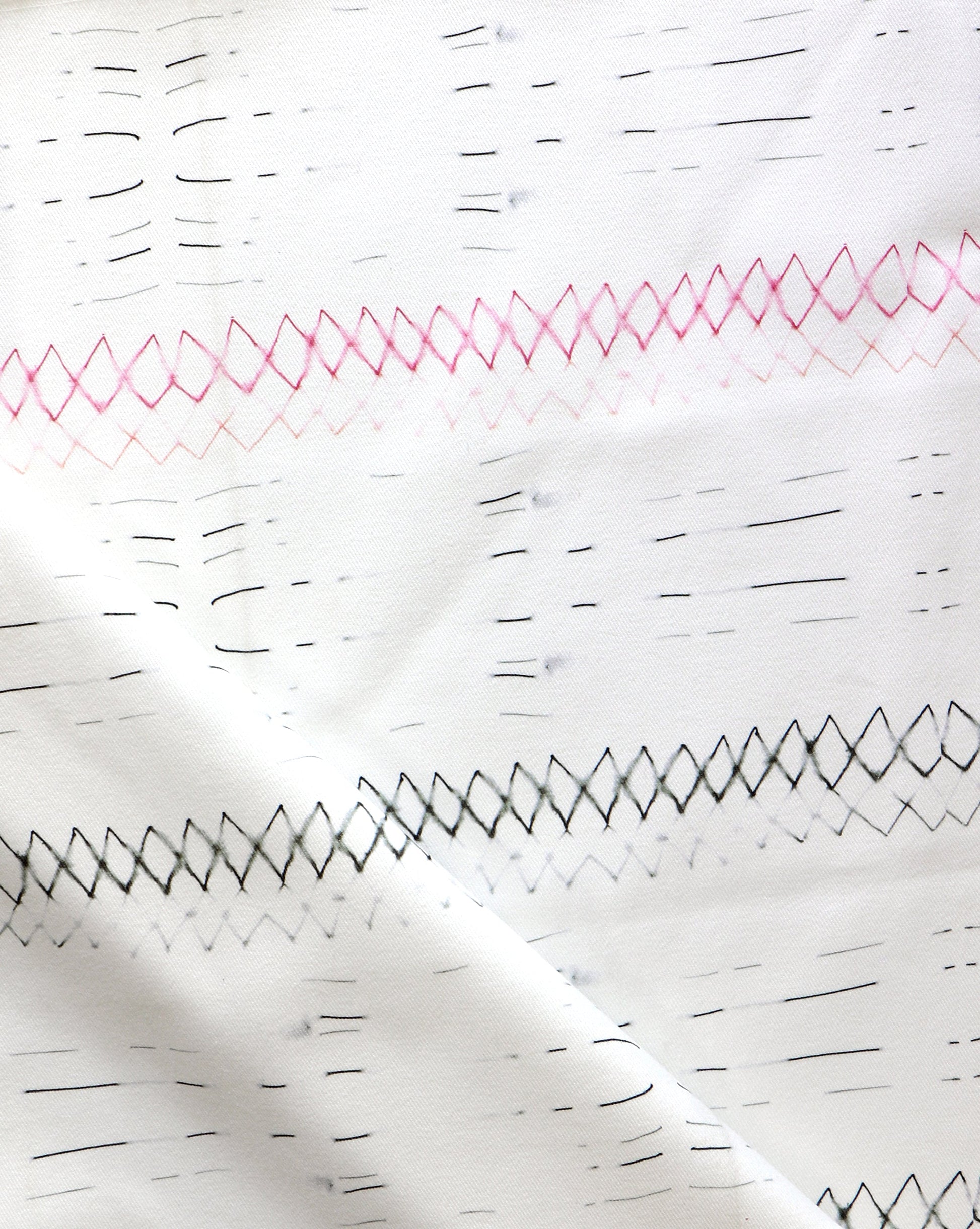 A close up of Native Stripe Fabric Black + Crimson with a graphic pattern of black and pink lines