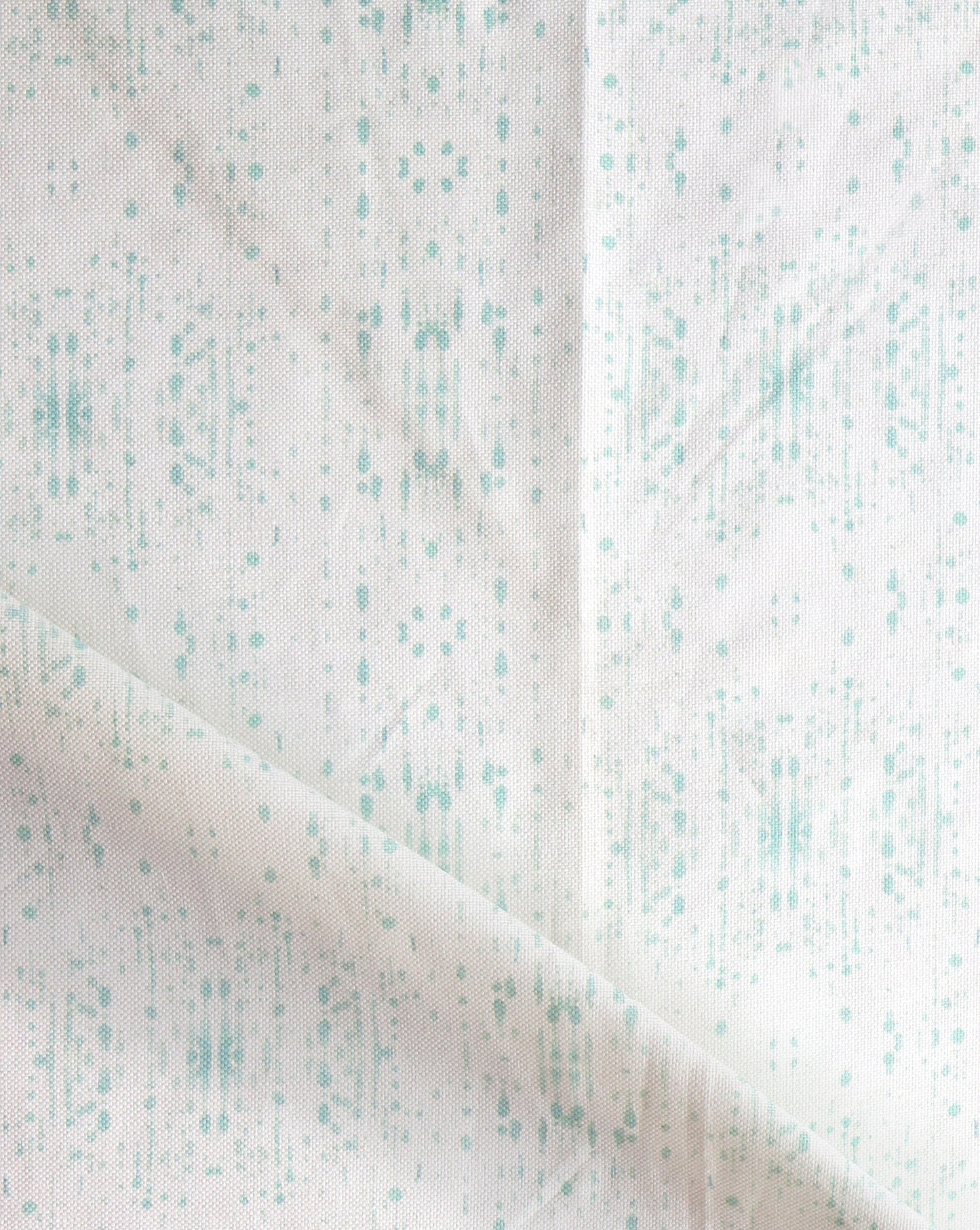A white and green Omaha Kinship Fabric Breeze with dots on it
