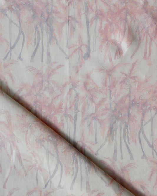 A pink and white Palm Dance Fabric Coral with palm trees on it