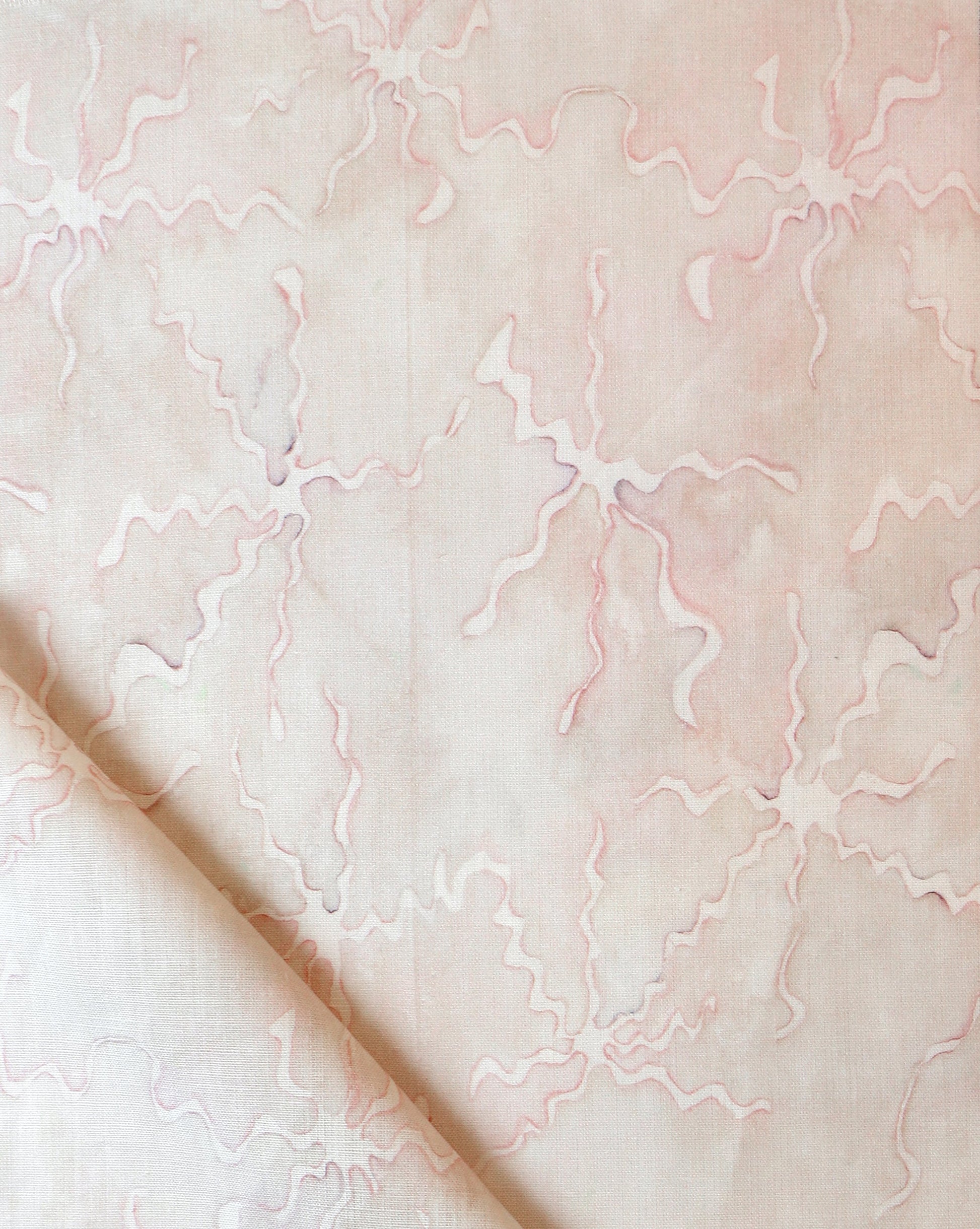 A pink and white Pecosa Fabric||Light Peach with a pattern on it.