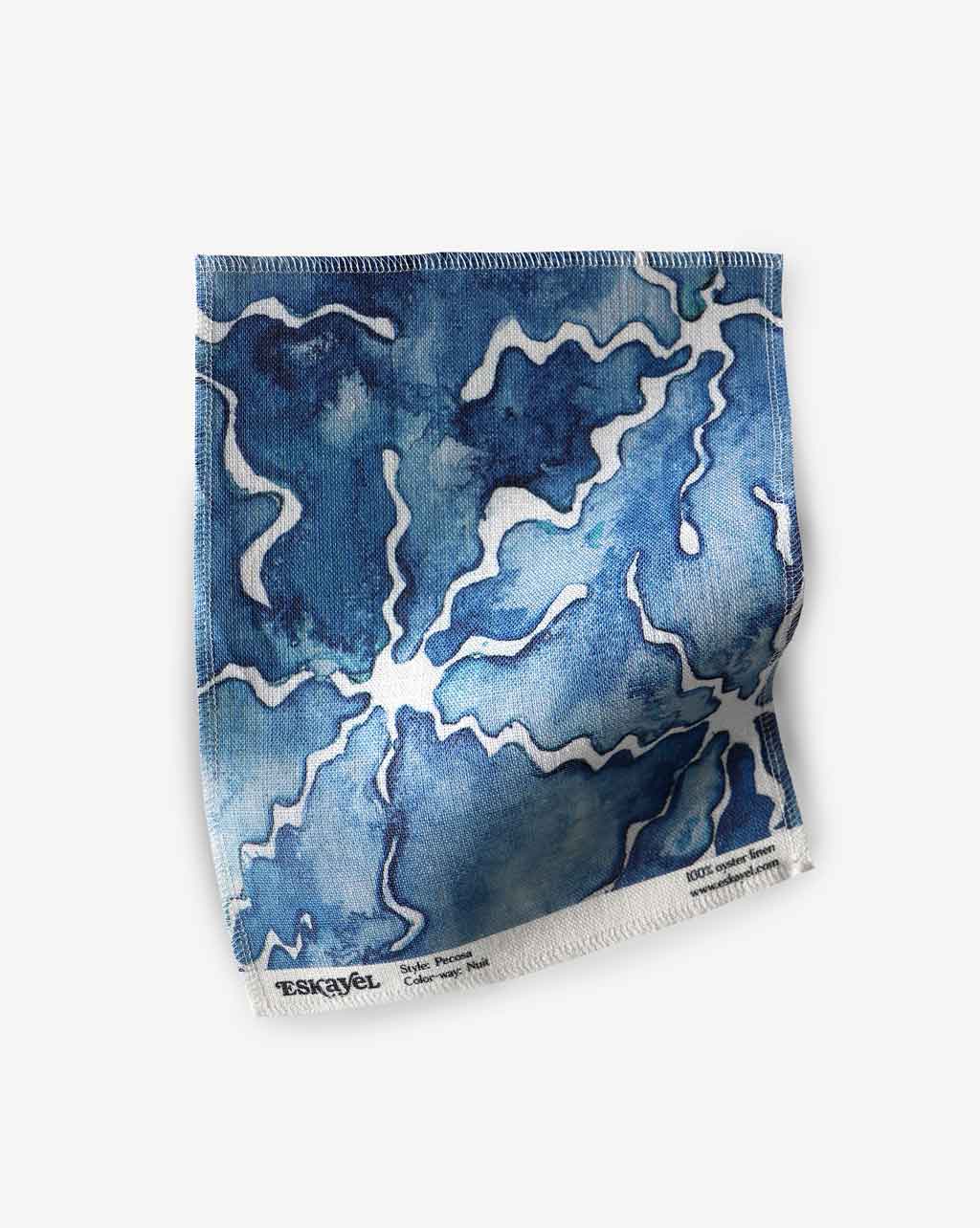 A blue and white Pecosa Fabric Nuit face cloth with a watercolor design