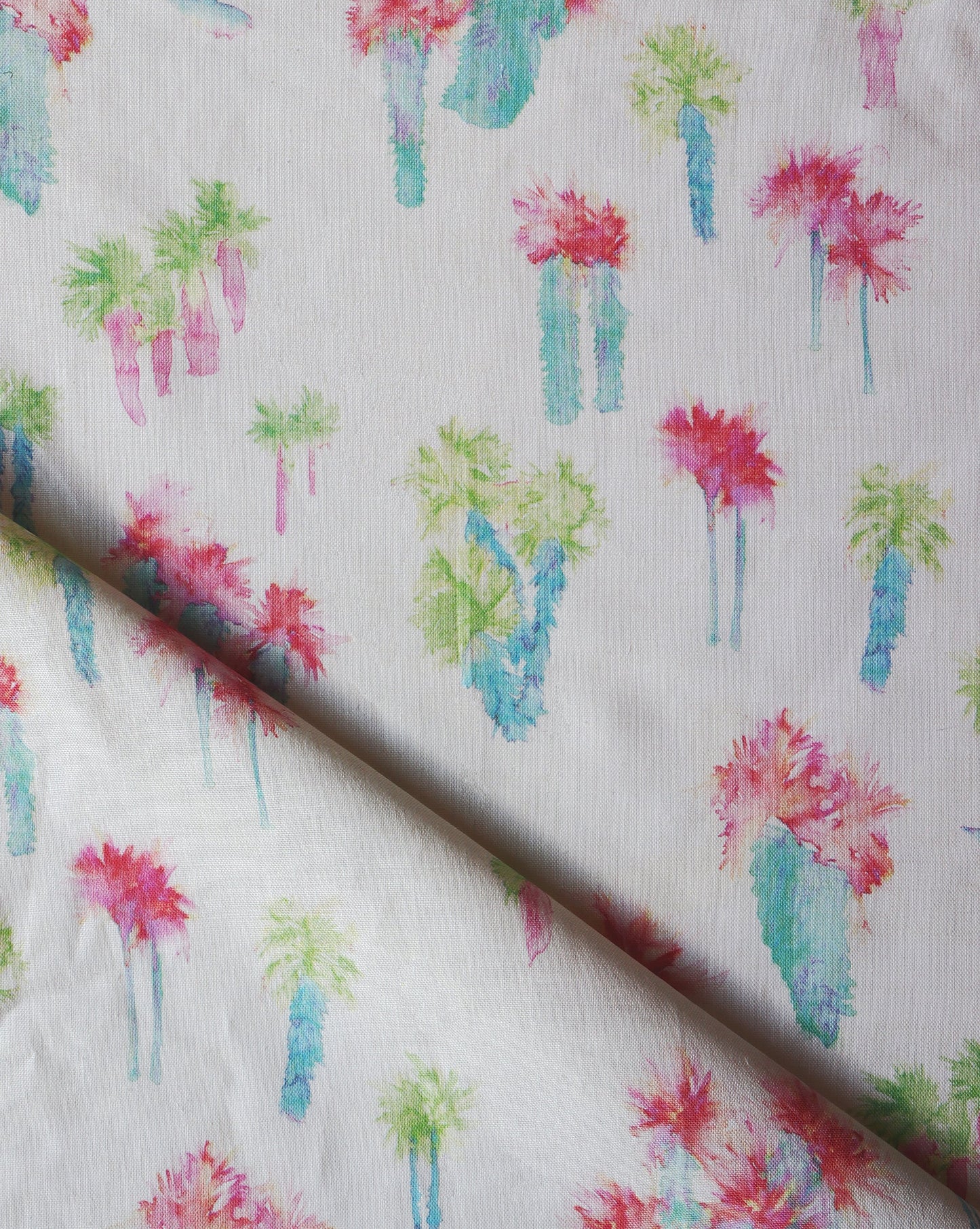 A close up of Perfect Palm Fabric Polychrome with watercolor style cactus trees on it