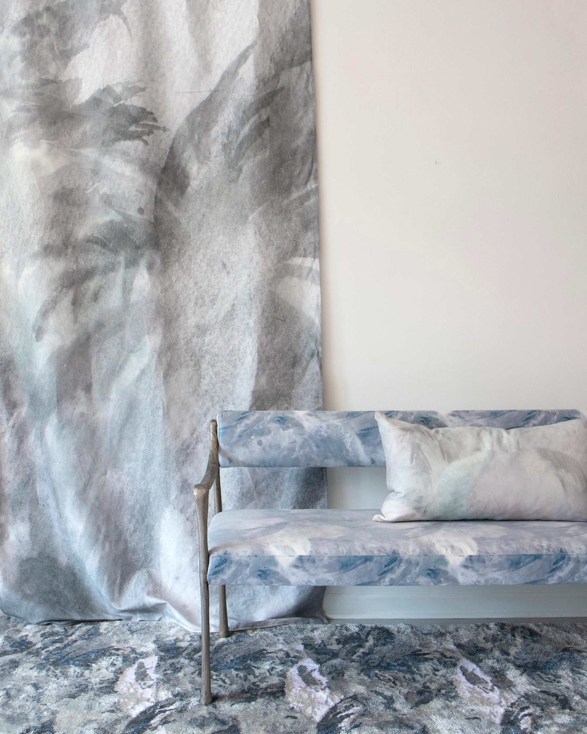 A bench in front of a wall with a Reflettere Fabric||Notte mural wallpaper.