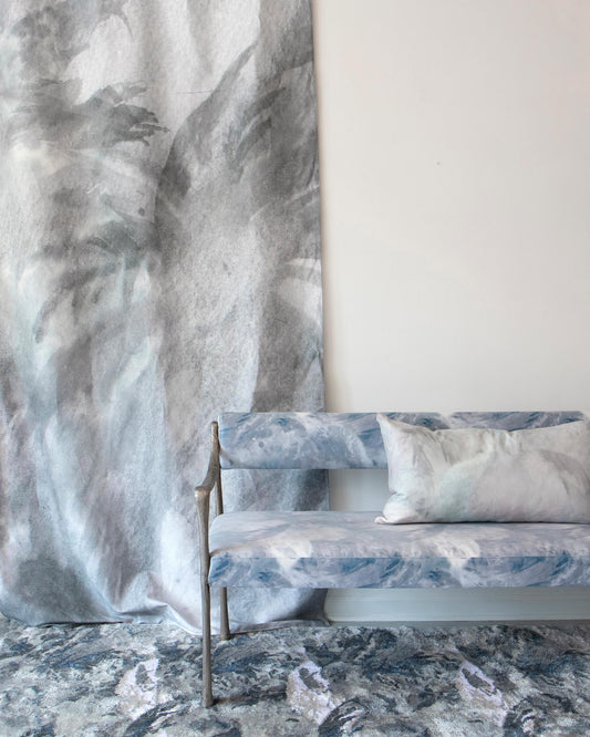 A bench in front of a wall with a Reflettere Fabric Notte mural wallpaper