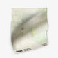 A white Regalo di Dio Fabric Luminosa with pale greens and green and white flowers on it